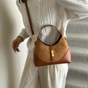 Detail of suede and leather crossbody bag with elegant gold metal buckle and lock