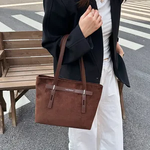Προβολή street style της σκούρας καφέ τσάντας tote με ματ φινίρισμα και λογότυπο