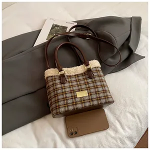 Detalle del bolso retro de cuadros con ribete de pelo sintético y placa dorada