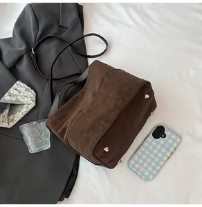 Dettaglio della borsa tote vintage marrone scuro con piedini metallici sulla base