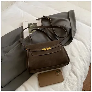 Detalle del bolso de hombro vintage marrón oscuro con textura mate y cierre dorado de lujo