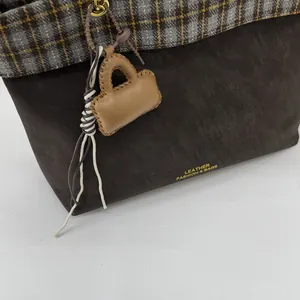 Detailansicht der Vintage-Tragetasche mit braunem Kunstleder und kariertem Stoffmuster