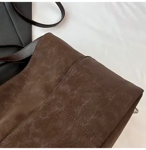 Dettaglio della cucitura ordinata sulla base della borsa tote marrone vintage opaca
