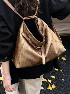 Vintage brown leather tote bag worn as a backpack on a street with autumn leaves