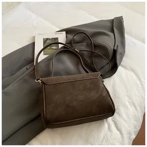 Detalle de bolso tote vintage marrón oscuro mate con correa ajustable y oro mate