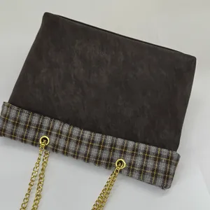 Detail der Vintage-Einkaufstasche aus braunem Leder mit Karo-Muster und Goldkette