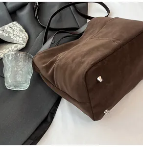 Dettaglio della borsa tote vintage marrone scuro con piedini protettivi in metallo