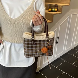 Detalle de bolso cubo de cuadros de invierno con ribete de felpa y asa de cuero