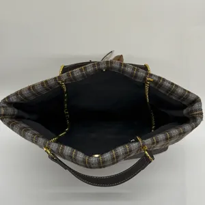 Detail der Vintage-Karo-Tasche mit Magnetverschluss und goldenem Kettenledergriff