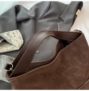 Dettaglio della pelle opaca vintage marrone scuro e cuciture sottili sulla borsa tote