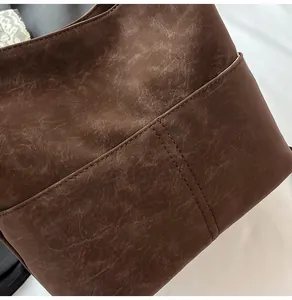 Dettaglio ravvicinato della borsa marrone retrò con pelle opaca e cuciture di precisione