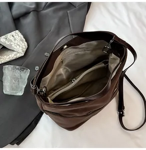 Vista interna della borsa tote marrone opaca con scomparti zip e fodera a spina pesce