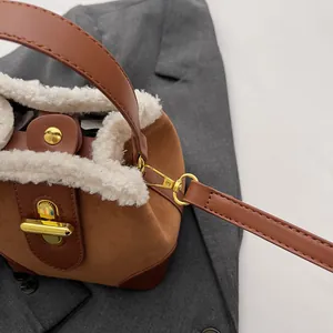 Détail du sac seau rétro en similicuir suédé avec bordure en fourrure et boucle dorée