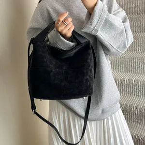 Dettaglio della borsa tote in pelle scamosciata nera con fibbie metalliche argentate