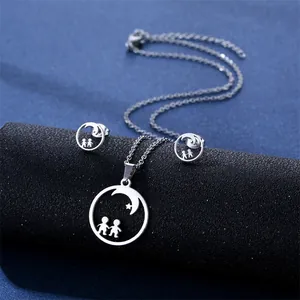 Detail of silver stainless steel necklace and earrings set featuring moon and star silhouettes
