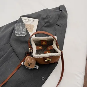 Vue de dessus du sac seau en daim vintage avec bordure en peau lainée et breloque ours