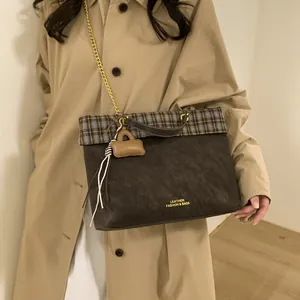 Details einer braunen Vintage-Tasche mit Karomuster und goldener Kette