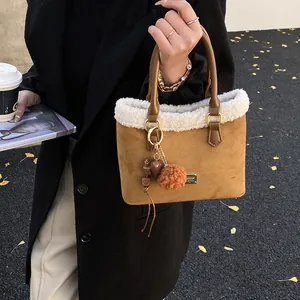 Detalle de bolso cubo de invierno en ante marrón con ribete de borreguillo sintético