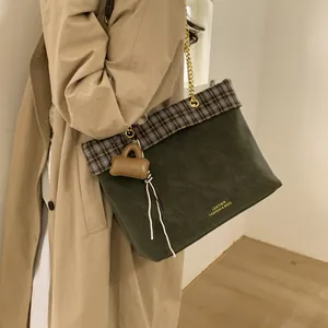 Detail des Vintage-Karomusters am olivgrünen Shopper mit goldener Metallkette