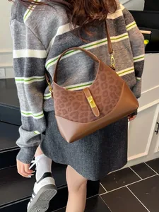Elegant brown leopard print crossbody dumpling bag with gold twist lock and shoulder strap