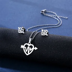 Detail of silver stainless steel heart and arrow jewelry set with ECG wave pattern