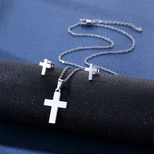 Detail shot of silver-tone stainless steel cross necklace and matching stud earrings set
