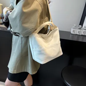 Dettaglio macro della borsa tote in pelle bianca con cuciture verticali e tracolla regolabile