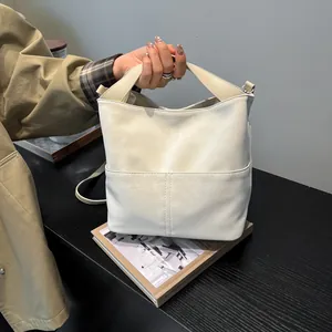 Dettaglio della borsa tote in ecopelle crema opaca con tasche esterne e tracolla regolabile
