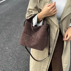 Dettaglio borsa tote marrone scuro opaco con trama scamosciata e design a secchiello