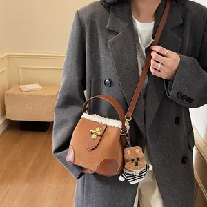 Détail du sac seau en daim marron avec bordure en fausse fourrure blanche et ourson