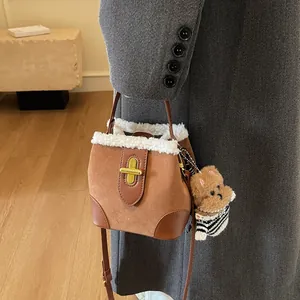 Détail du sac seau vintage en daim avec bordure en peau lainée et charm peluche chien