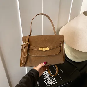 Detalle del bolso tote marrón vintage con cierre dorado y correa ajustable