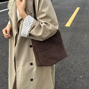 Dettaglio borsa tote in pelle smerigliata marrone scuro con tracolla e tasca laterale