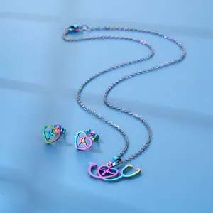 Rainbow plated stethoscope heart necklace and earrings set on a blue textured background