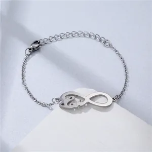 Macro detail of silver stainless steel chain bracelet with infinity love charm and lobster clasp