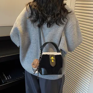 Détail du sac seau en daim noir avec bordure en fausse fourrure et petit ours