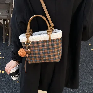 Λεπτομέρεια καρό τσάντας κουβά με επένδυση προβάτου και καφέ δερμάτινη δετή λαβή