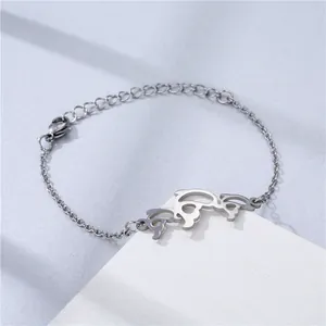 Macro shot of silver dolphin charms and lobster clasp on an adjustable steel bracelet