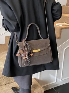 Bolso tote retro marrón mate con hebilla dorada y dije de perro salchicha usado por modelo