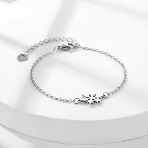 Polished stainless steel snowflake pendant bracelet with adjustable heart charm on white base