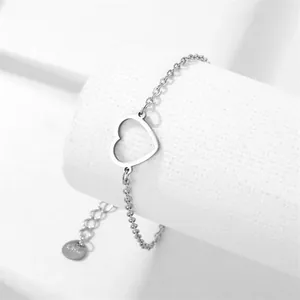 Gepolijste roestvrijstalen armband met hol hartje op een wit podium gepresenteerd