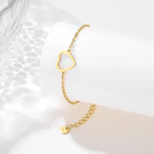 Golden stainless steel heart bracelet with hollow design on white minimalist stand