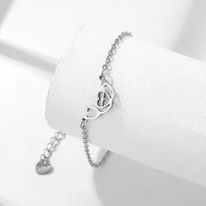 Polished stainless steel stethoscope heart bracelet with EKG pulse on white stand