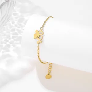 Golden stainless steel LOVE letter bracelet with heart pendant on white pedestal