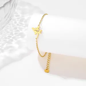 Elegant gold stainless steel dragonfly charm bracelet displayed on a white stand
