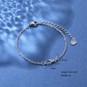 Detail van roestvrijstalen armband met hartvormige hanger en karabijnsluiting op blauwe achtergrond