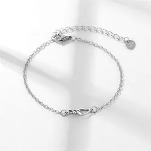Gepolijste roestvrijstalen hartjesarmband met holle belettering op witte achtergrond