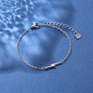 Close-up of lightning bolt pendant bracelet with S.Steel heart tag on blue background