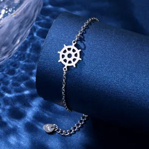 Silver stainless steel nautical ship wheel bracelet with heart tag on blue display