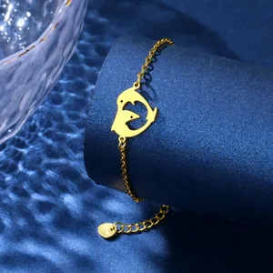 Gold dolphin heart charm bracelet in stainless steel on blue water ripple background